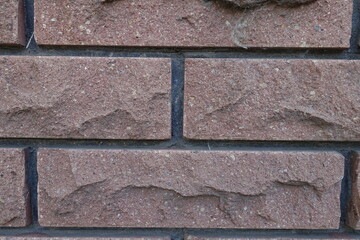 Closeup of brown brick veneer wall with black mortar joints