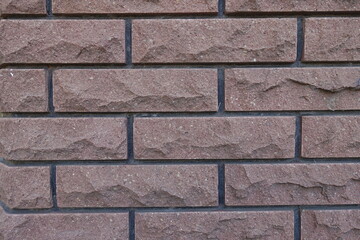 Pinkish brown brick veneer wall with black mortar joints