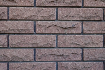 Texture of brown brick veneer wall with black mortar joints