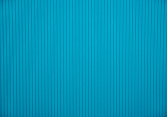 Abstract background made of corrugated paper for blue application. Space for text. Texture. Vertical stripes.
