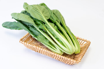 The fresh vegetables in the basket are placed on the white table
