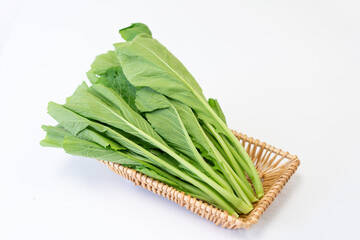 The fresh vegetables in the basket are placed on the white table