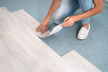 Installing New Vinyl Laminate. Woman Fixing Floor