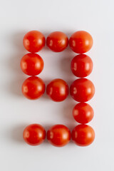 Number nine. A figure of cherry tomatoes on a white background. Tomatoes close-up. Tomatoes in the form of the Number nine