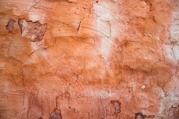 The texture of a red concrete wall with cracks and scratches can be used as a background