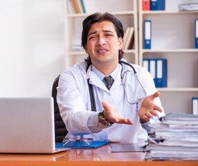 Young handsome doctor working in the clinic