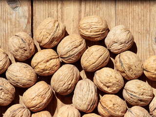 Walnuts on a wooden table in the bright sun.