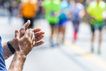 Clapping hands of an unrecognizable woman at an athletics marathon, sports concept.