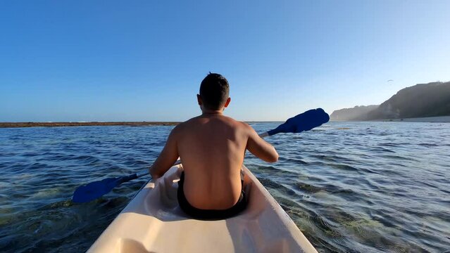 Indonesian Man Canoeing Canoe at Gunung Payung Beach, Bali, Indonesia
