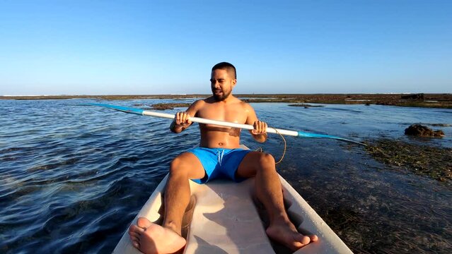 Indonesian Man Canoeing Canoe at Gunung Payung Beach, Bali, Indonesia