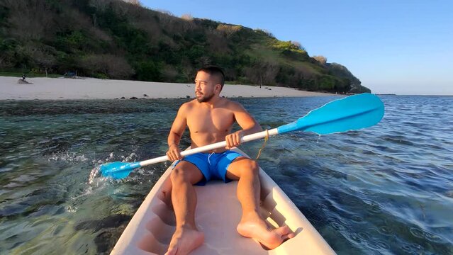 Indonesian Man Canoeing Canoe at Gunung Payung Beach, Bali, Indonesia