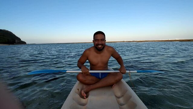 Indonesian Man Canoeing Canoe at Gunung Payung Beach, Bali, Indonesia