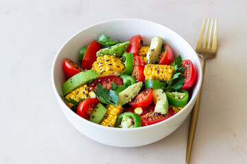Salad with corn, avocado, tomatoes, peppers and parsley. Healthy eating. Vegetarian food.