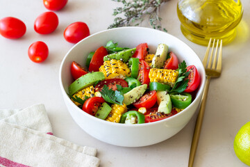 Salad with corn, avocado, tomatoes, peppers and parsley. Healthy eating. Vegetarian food.