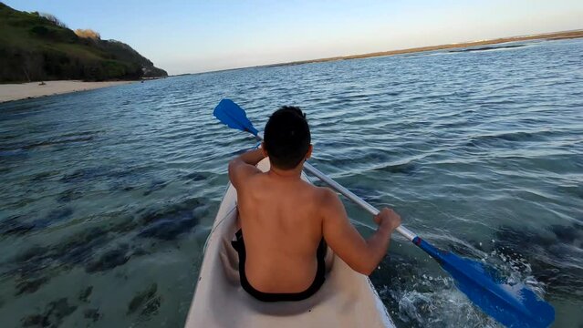 Indonesian Man Canoeing Canoe at Gunung Payung Beach, Bali, Indonesia