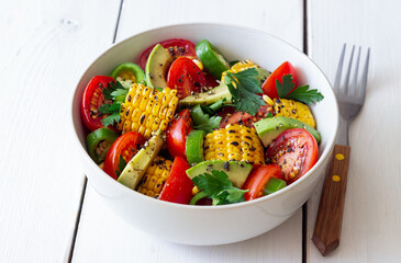 Salad with corn, avocado, tomatoes, peppers and parsley. Healthy eating. Vegetarian food.
