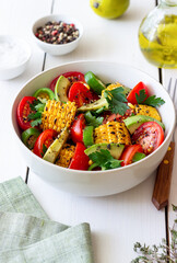 Salad with corn, avocado, tomatoes, peppers and parsley. Healthy eating. Vegetarian food.
