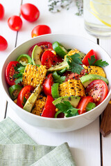 Salad with corn, avocado, tomatoes, peppers and parsley. Healthy eating. Vegetarian food.