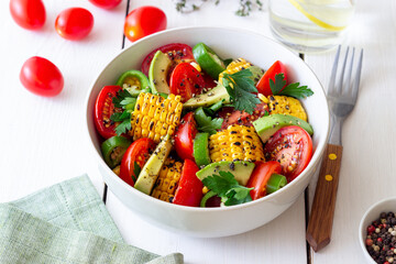Salad with corn, avocado, tomatoes, peppers and parsley. Healthy eating. Vegetarian food.