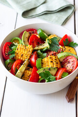 Salad with corn, avocado, tomatoes, peppers and parsley. Healthy eating. Vegetarian food.