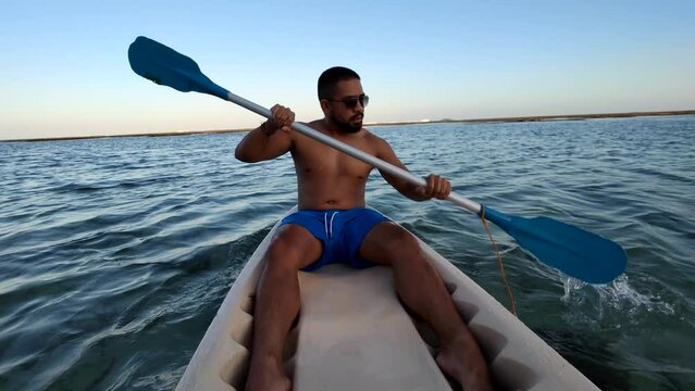 Indonesian Man Canoeing Canoe at Gunung Payung Beach, Bali, Indonesia