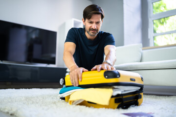 Man Packing Stuffed Suitcase Bag