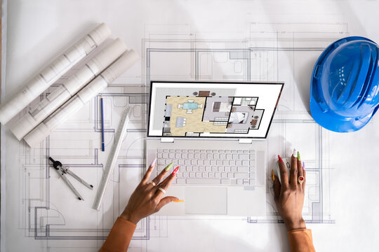 Architect Looking At Designs Of House On Laptop
