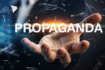 Hand of a businessman presenting the word propaganda. Propaganda concept in business, politics or...