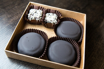 Chocolate candies and sweets in a box on a rustic background