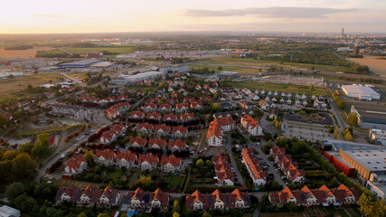 osiedle domy mieszkalne z drona w tle Wrocław i Sky Tower o zachodzie słońca - obrazy, fototapety, plakaty