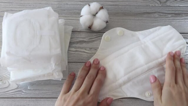 The woman looks at the reusable pad and then throws out the disposable pads. Zero waste, stop plastic.