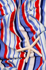 Fototapeta premium Bed linen surface at the resort. Close-up of soft multicolored wave patterns, fabric texture as background. Sea vacation, beach season. Towel on a sun lounger