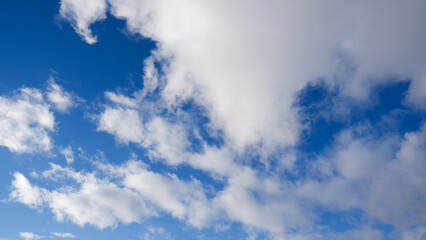 Sky with clouds and sun. White colour clouds against blue sky