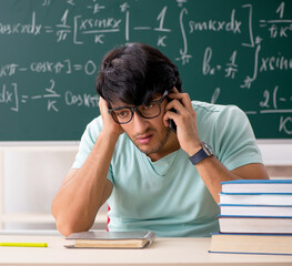 Young male student mathematician in front of chalkboard