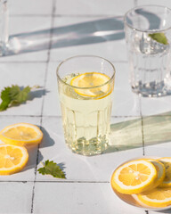 Fresh summer cocktail with lemons and mint. Summer drinks and vacation concept. Sunny day shadows