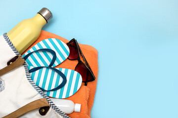 beach accessories - a bottle with a soft drink, sun cream, sunglasses, flip flops, a towel in a...