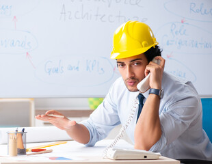 Young male architect in front of the whiteboard