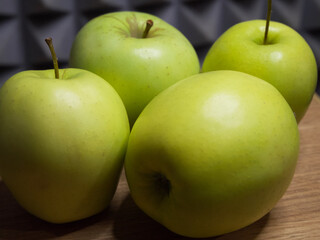 Four large apples, close-up. Fruit on a wooden surface.