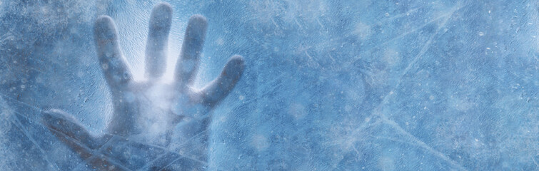 Banner of human hand against frozen glass and blue background. Energy Crisis Concept. Cold winter 2022