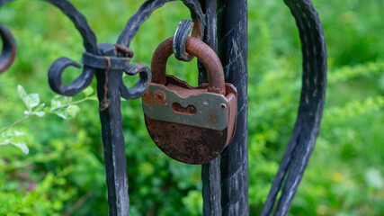 Old, rusty locks on the metal grating of the city alley.