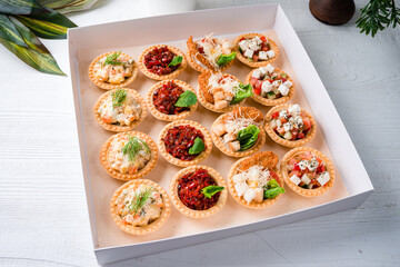 Snack food delivery for catering. box with canape snacks shot Fresh tapas