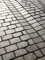Background texture of tiled stone road. Grey rough bricks.