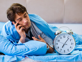 Employee in the bedroom being late for his job in time managemen