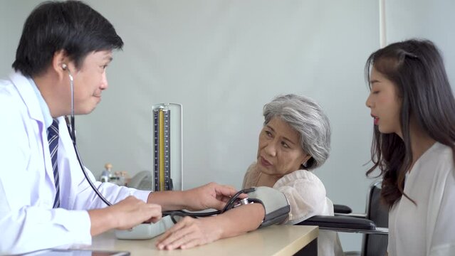 Asian young woman and her mother taking to doctor.