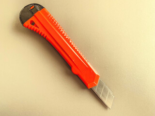 stationery on the table in the office. stationery knife with a red, plastic handle. paper cutting,...