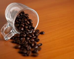 Coffee beans spiling out of a glass cup