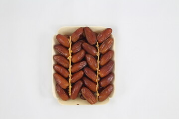 Cardboard tray of date fruits on grey background