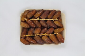 Cardboard tray of date fruits on grey background