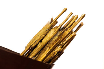 Detail of the golden feathers of arrows, used as an ancient weapon.