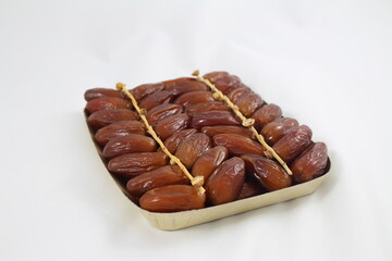 Cardboard tray of date fruits on grey background